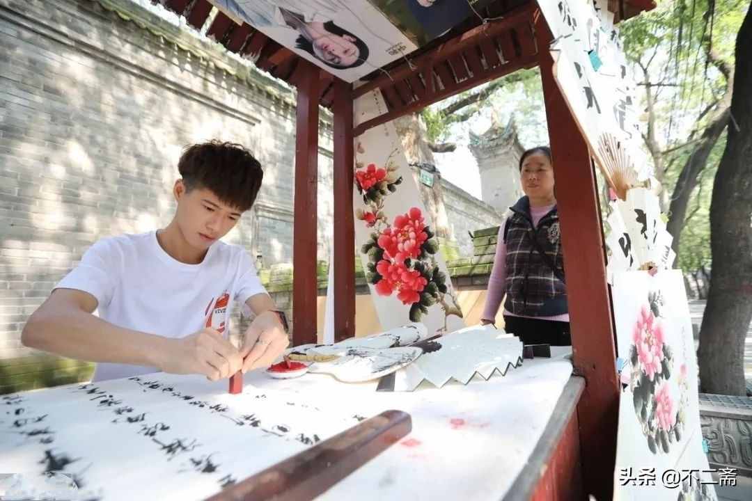 小伙子摆摊卖书画，月入5万，还收了5个徒弟，网友：人帅字画美