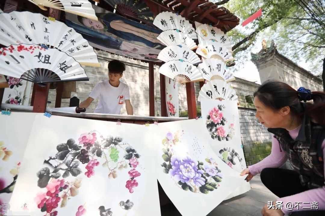 小伙子摆摊卖书画，月入5万，还收了5个徒弟，网友：人帅字画美