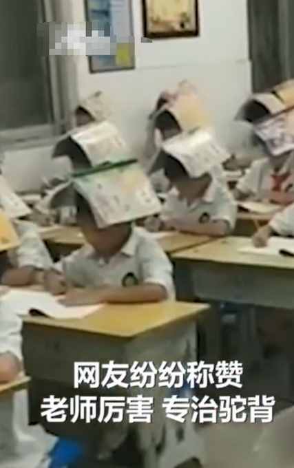 小学生头顶课本写字，网友：还是老师厉害，专治驼背